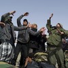 Libyan rebellion supporters perform a song to cheer fighters heading to the frontline from the eastern town of Ajdabiya on April 6, 2011.